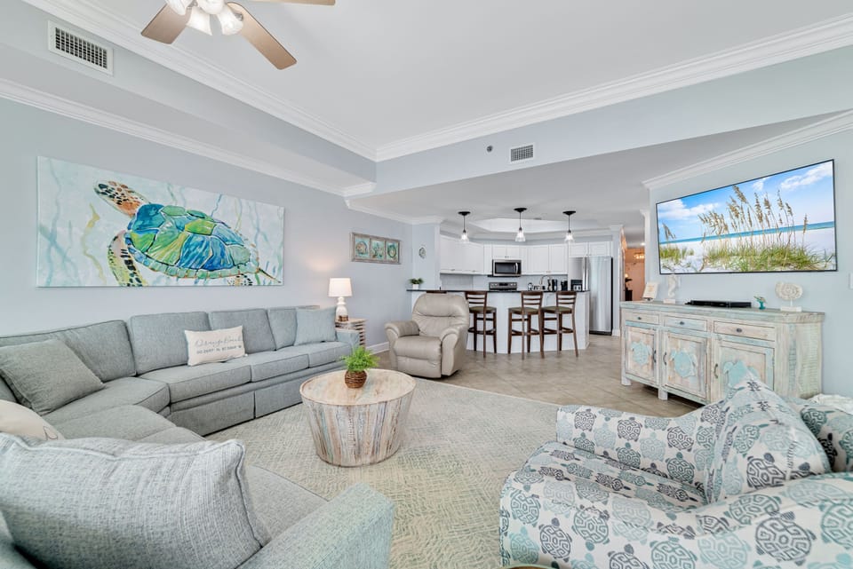 Designed for relaxation and convenience. This expansive space features a comfortable, family-sized sectional, dedicated dining seating, and a modern fully-equipped kitchen, all within a bright, airy coastal setting.