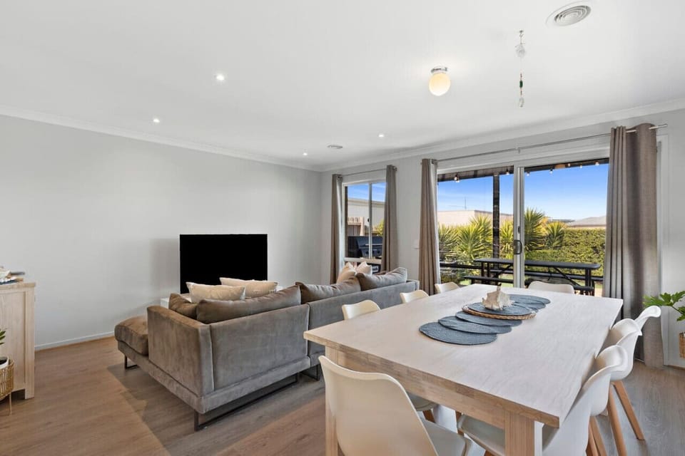 🛋️ Bright open-plan living and dining area flowing onto a private balcony with outdoor seating