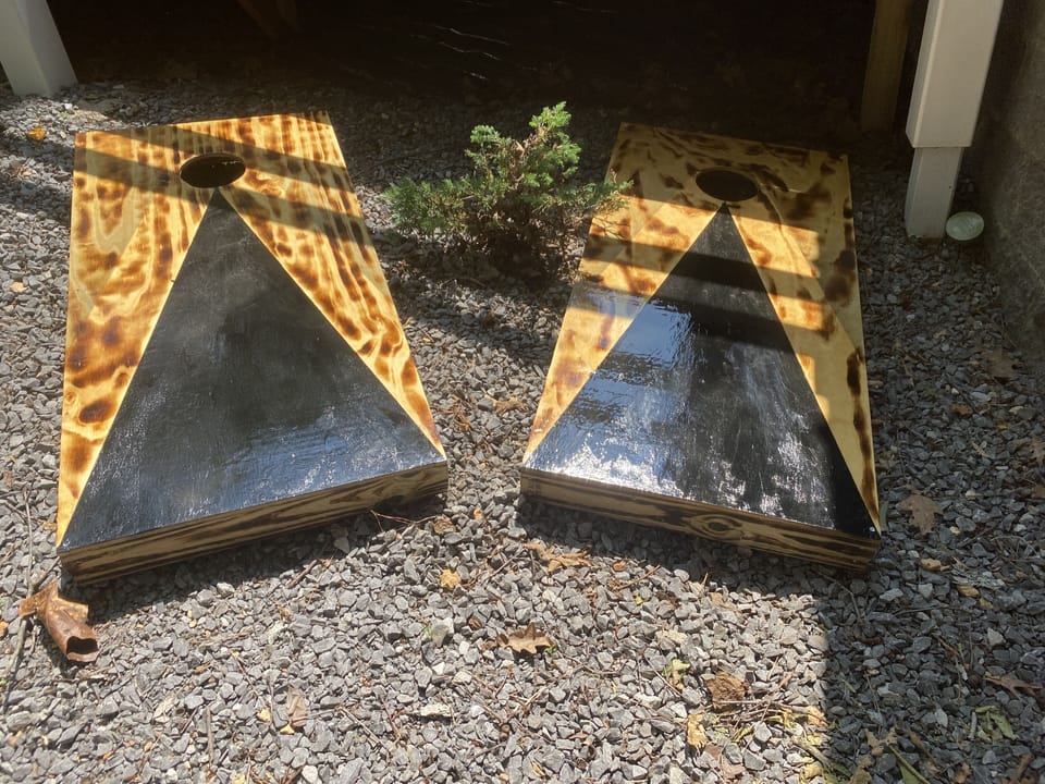 Corn hole boards stored under the porch
