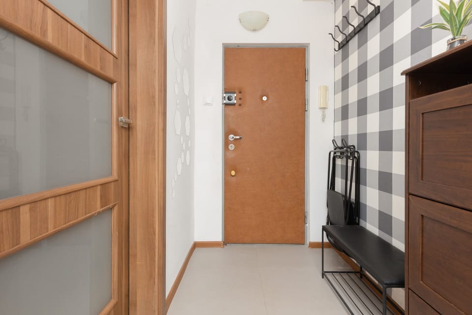 A well-lit entrance hallway featuring modern furniture and ample storage for shoes and outerwear.

