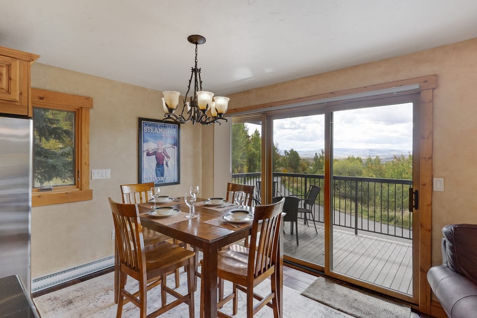 Wood dining table with seating for 4. Large windows with views of the yampa valley