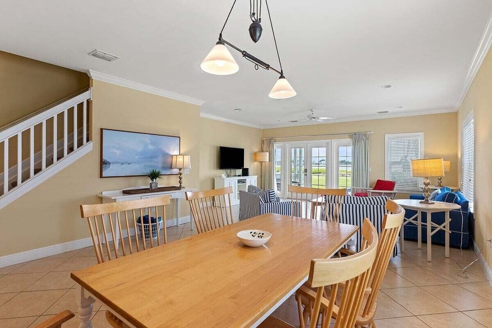 Gather around the large wooden dining table with easy access to the open kitchen, living room, and outdoor porch.