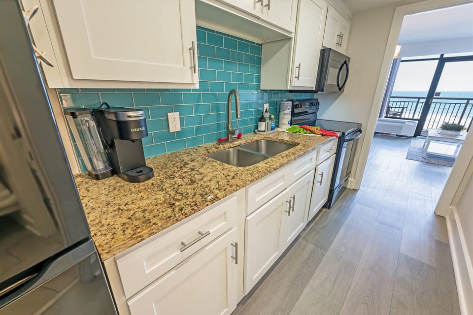 - Cook with a view in this modern, fully stocked kitchen featuring stylish blue accents - Granite countertops, stainless steel appliances, & everything you need for easy meals - Whether you're brewing coffee or making dinner, the ocean is always in sight
