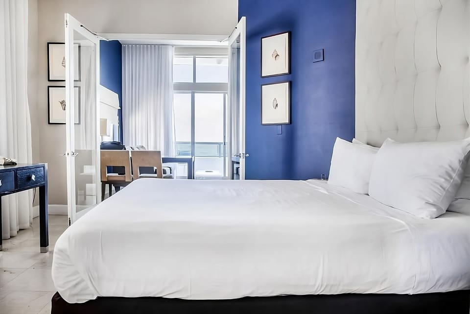 Unwind in crisp linens with breezy balcony daylight.