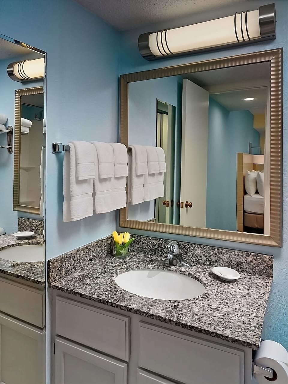 Refresh at a granite vanity with bright, flattering mirrors.