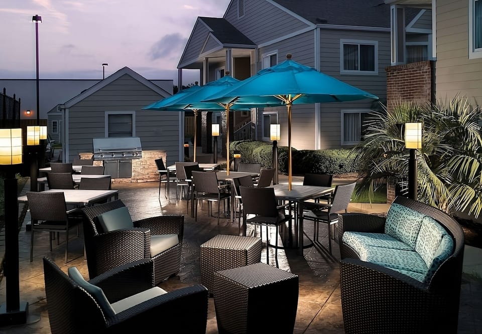 Linger outdoors under umbrellas and glow lighting for easy evenings.