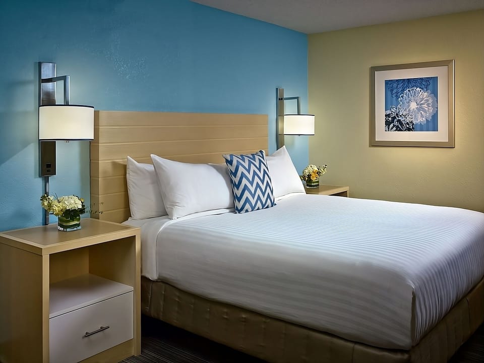 Drift off fast in a plush bed with warm lighting.