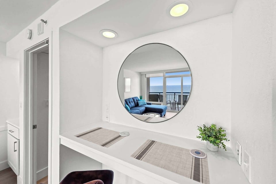 Enjoy ocean views from every angle—even while dining at this stylish breakfast nook. The round mirror perfectly frames the coastal scenery, creating a bright and inviting space to start your day by the sea.
