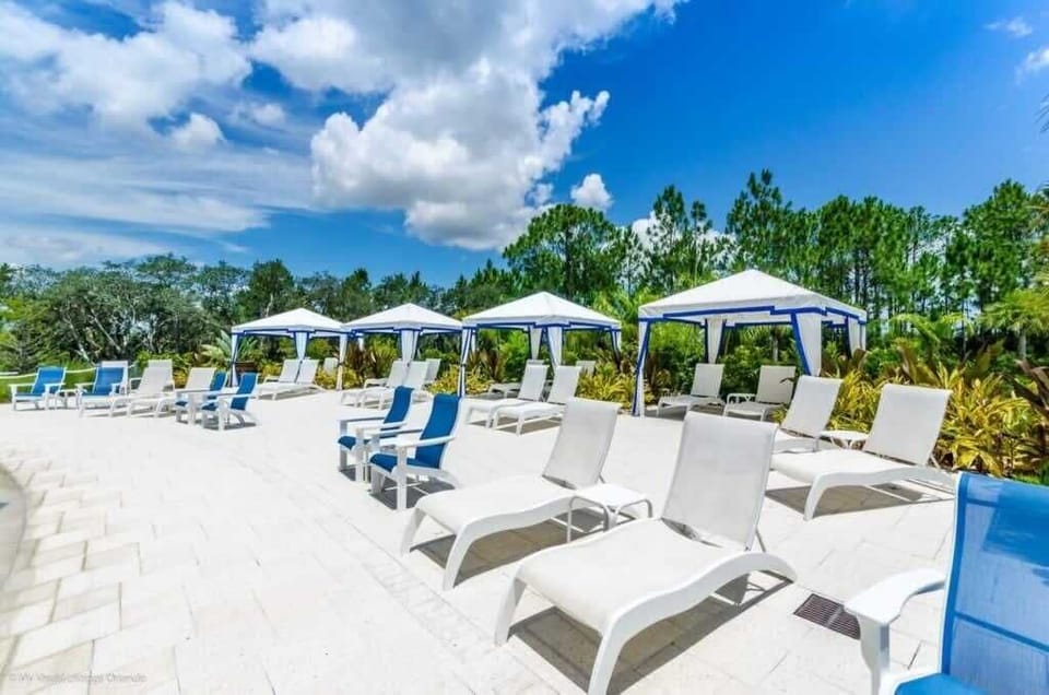 - Sunny pool deck with shaded cabanas, lounge chairs, and open views  
- Outdoor relaxation area perfect for swimming, sunbathing, and breaks  
- Resort amenities surrounded by greenery and wide open skies  
