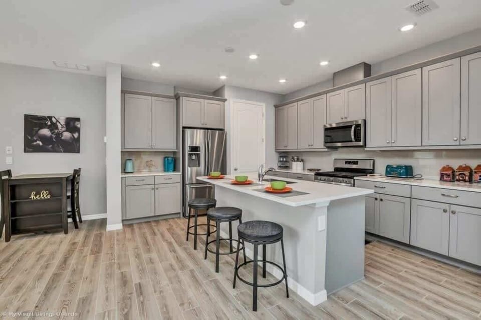 - Open kitchen with large island seating, stainless appliances, and bright lighting  
- Modern layout designed for cooking meals, shared prep, and group dining  
- Clean finishes with storage space, smooth floors, and easy daily flow  
