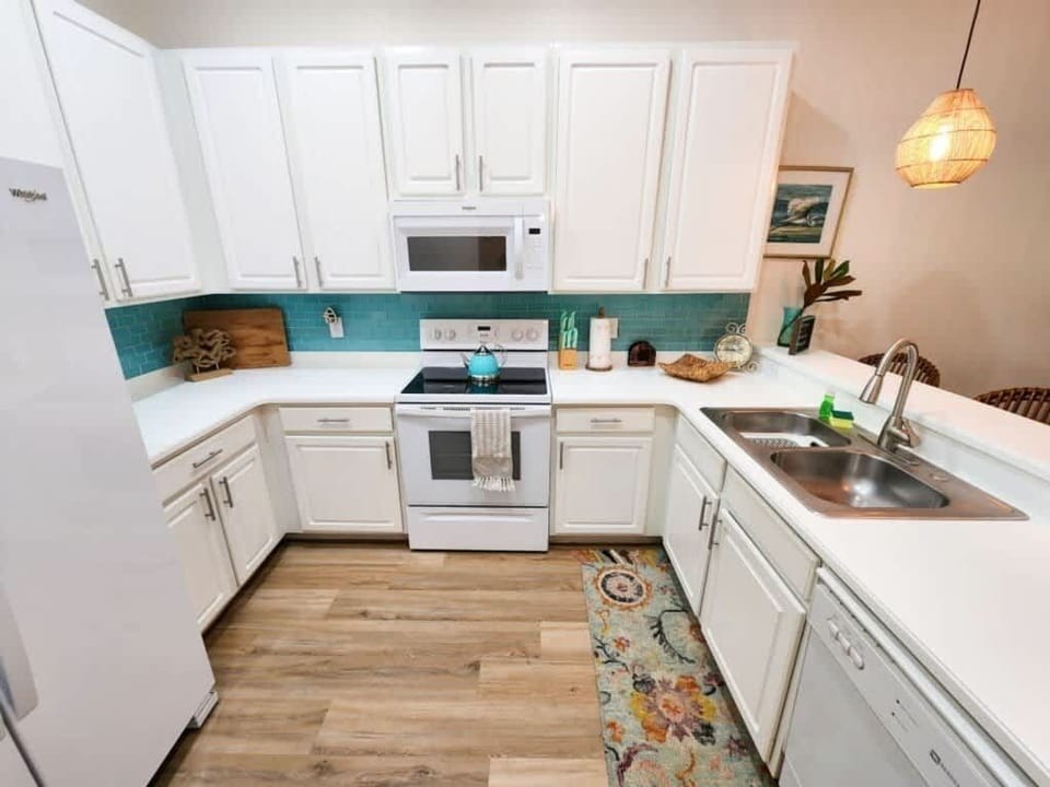 - Fully equipped kitchen with white cabinets modern appliances and prep space
- Open kitchen ideal for home cooking family meals and longer Airbnb stays
- Clean bright kitchen adds comfort convenience and value to your stay  