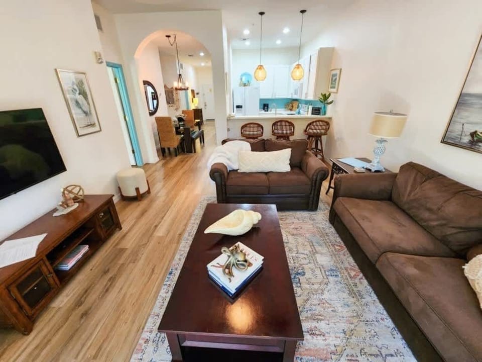 - Bright living room with sofa seating smart TV and open layout for family stays
- Comfortable lounge space connected to dining and kitchen for easy gatherings
- Vacation rental living area ideal for relaxing nights and shared moments 