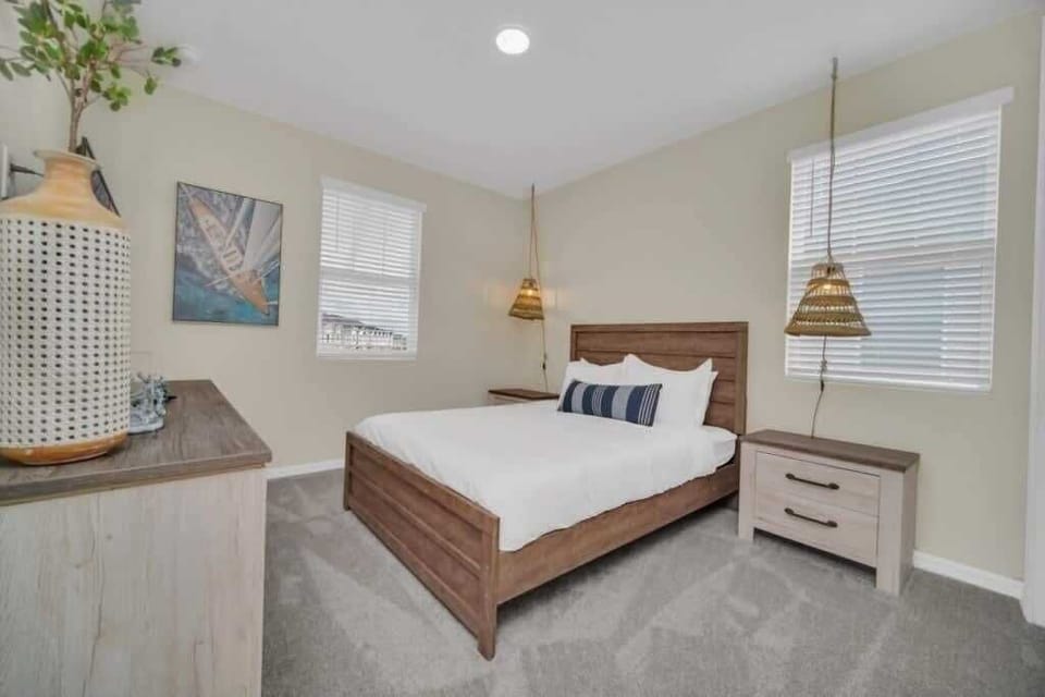 - Cozy bedroom with queen bed soft carpet and pendant lights on both sides
- Bright windows neutral tones and calm decor for restful sleep
- Ideal space for couples longer stays and peaceful nights  

