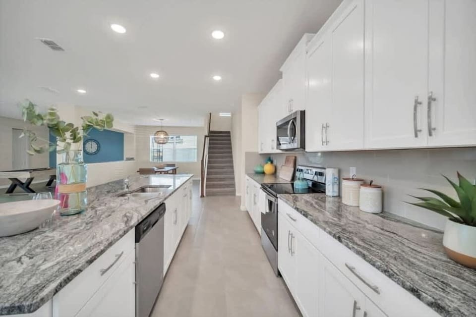 - Wide galley kitchen with double counters modern appliances and lighting
- Efficient layout makes cooking easy for groups and longer stays
- Bright finishes clean lines and open view to living space  