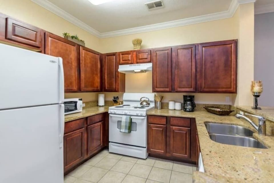 - Fully equipped kitchen with spacious counters for easy cooking
- Warm wood cabinets and essential appliances ready for meals
- Create breakfast to dinner moments in this inviting setup
