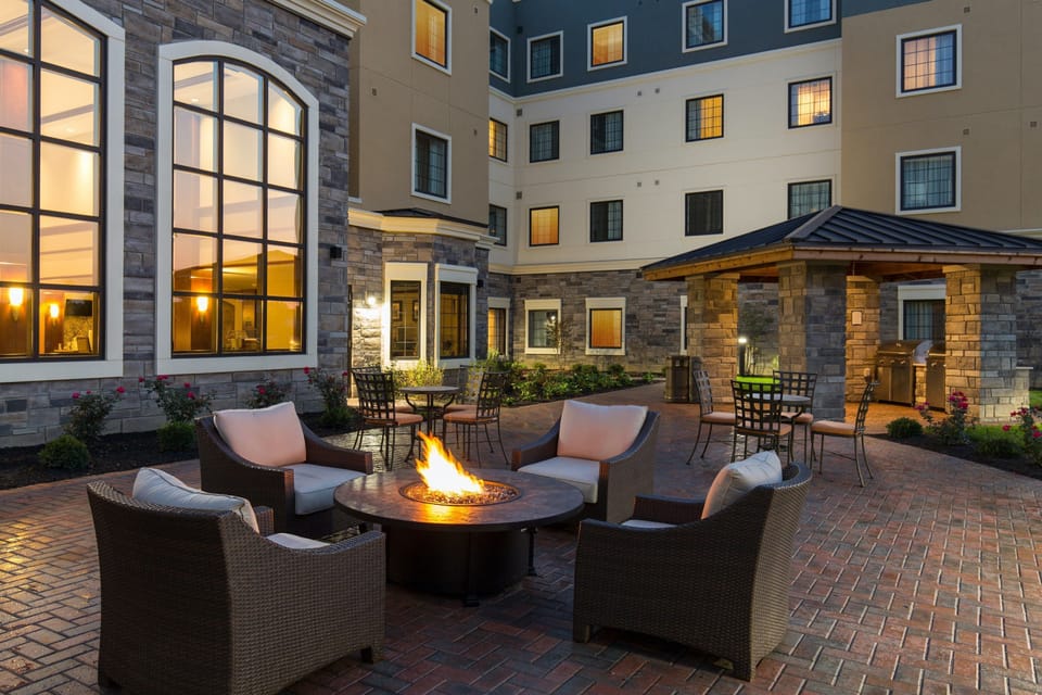 Evening courtyard with fire pit and outdoor lounge seating.