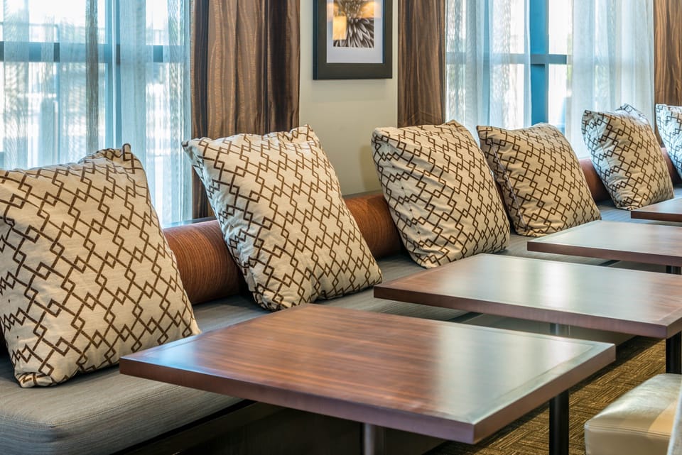 Welcoming common area with decorative cushions and natural light.