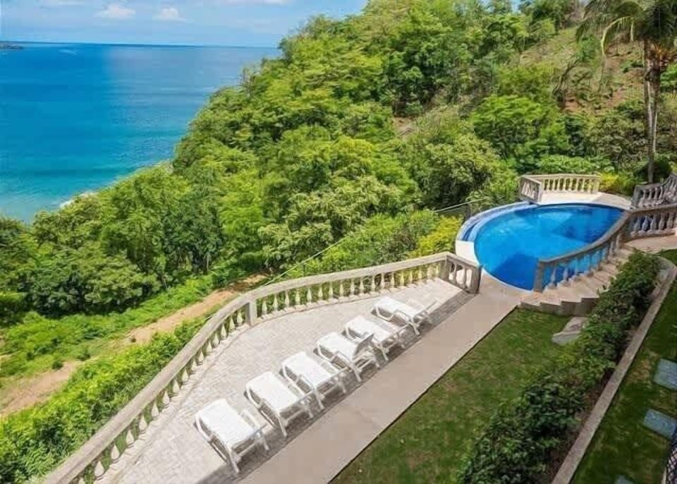 Spacious pool terrace with sun loungers and panoramic views.