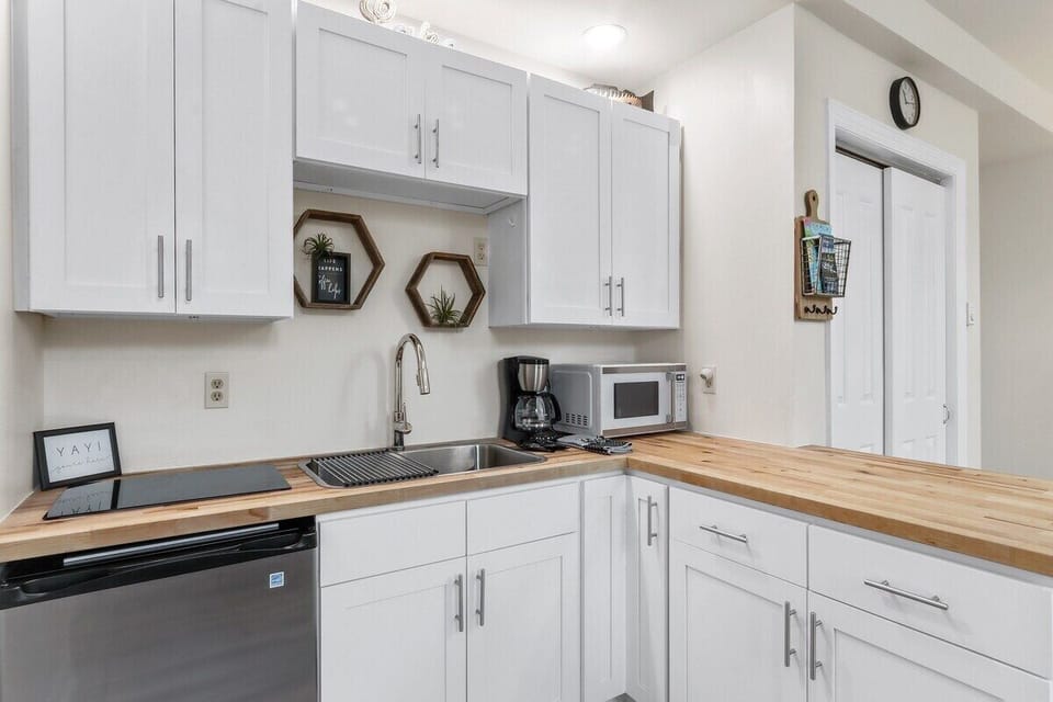 Galley kitchen with electric stove top, microwave, mini fridge