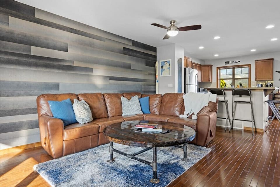 Living room with a Smart TV, cozy reclining sofa and a decorative fireplace (please note it is on-functional)