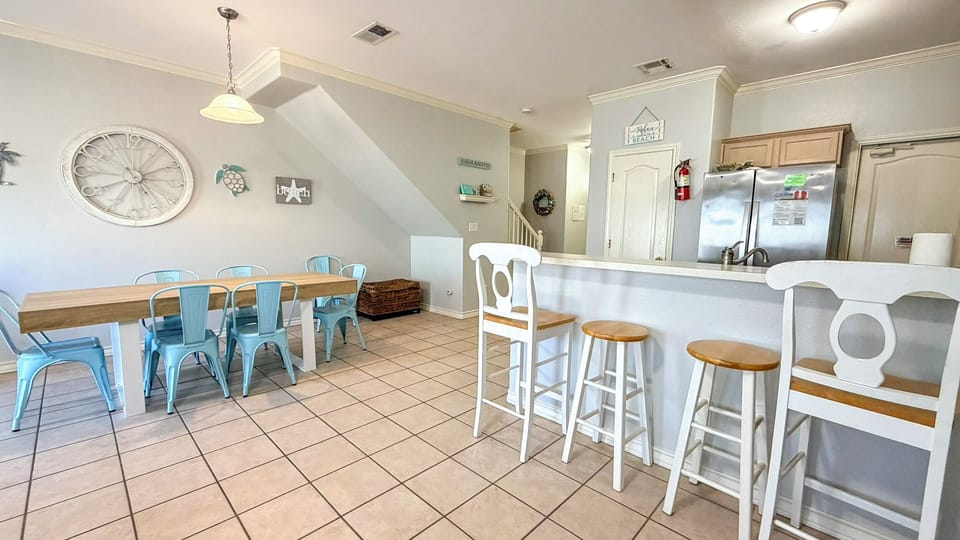 Gather around your bright kitchen island or dining table with coastal charm and turquoise chairs welcoming memorable meals together.