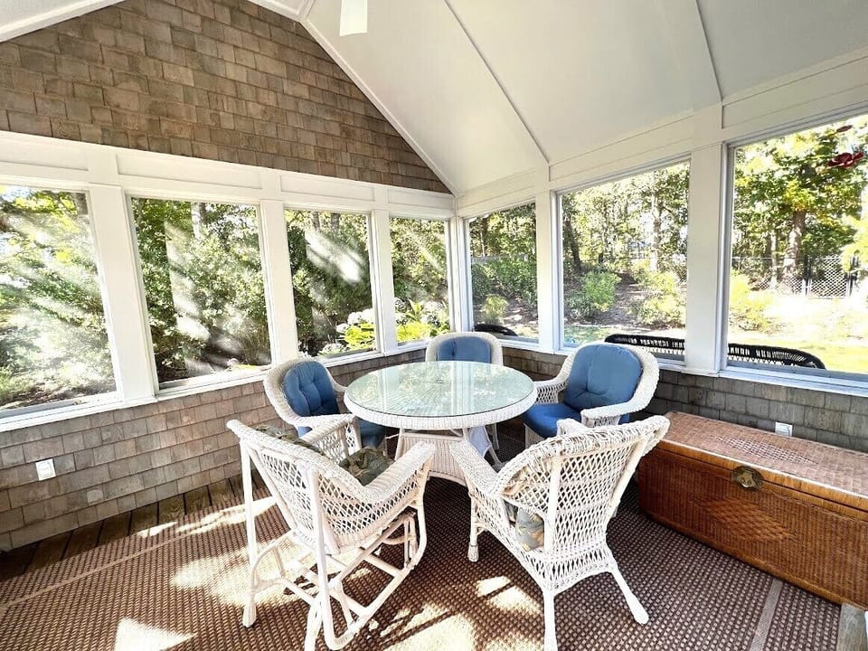 Screened porch overlooks pool and gardens