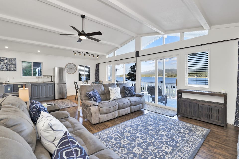 Cozy mountain living room with a stone fireplace, comfy seating, and smart TV—perfect for relaxing evenings, movie nights, and warm cabin vibes after outdoor adventures.