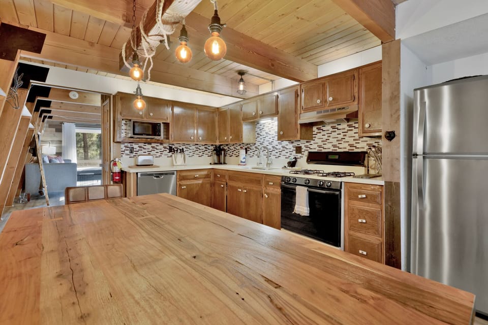 Fully equipped cabin kitchen with ample cabinetry, stove, fridge, microwave, and coffee maker, perfect for cooking meals, morning coffee, and feeling right at home on your stay.