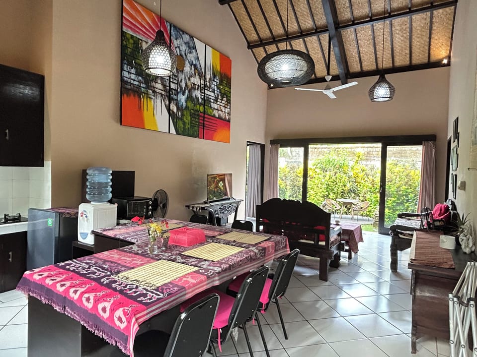 Cozy living room with high ceilings, garden views, kitchenette & large desk.