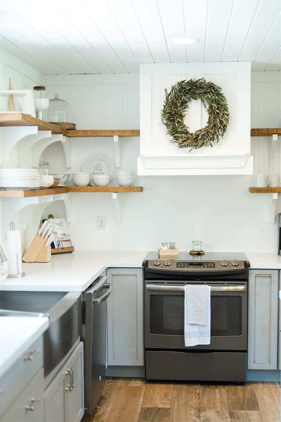 Flat stove top and dishwasher, and farm-style sink make cleanup a breeze. The open shelves beautifully display all cups and bowls.