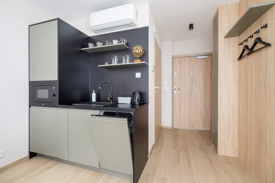 A compact kitchenette with sleek cabinetry, located near the entrance, combining style and practicality.