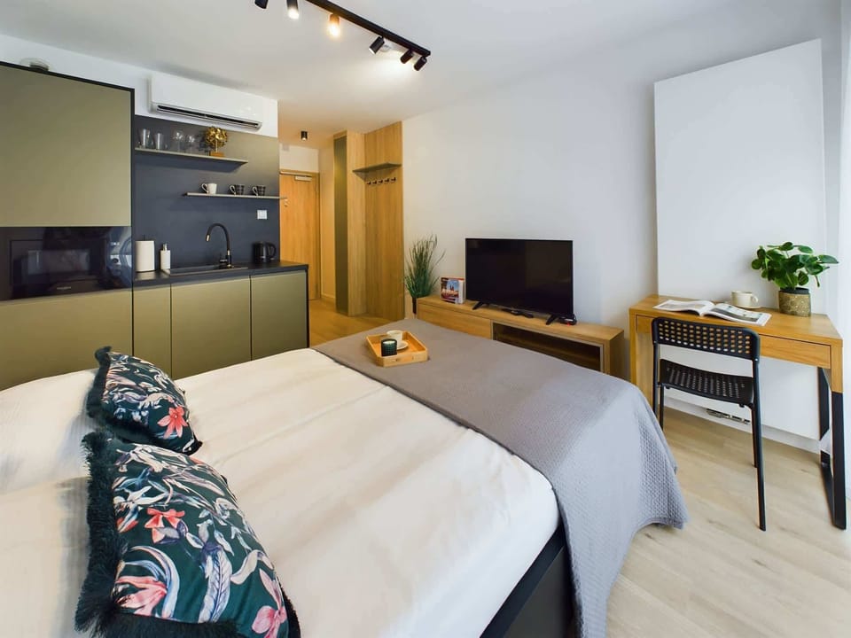 The bedroom area is harmoniously connected to the kitchenette.