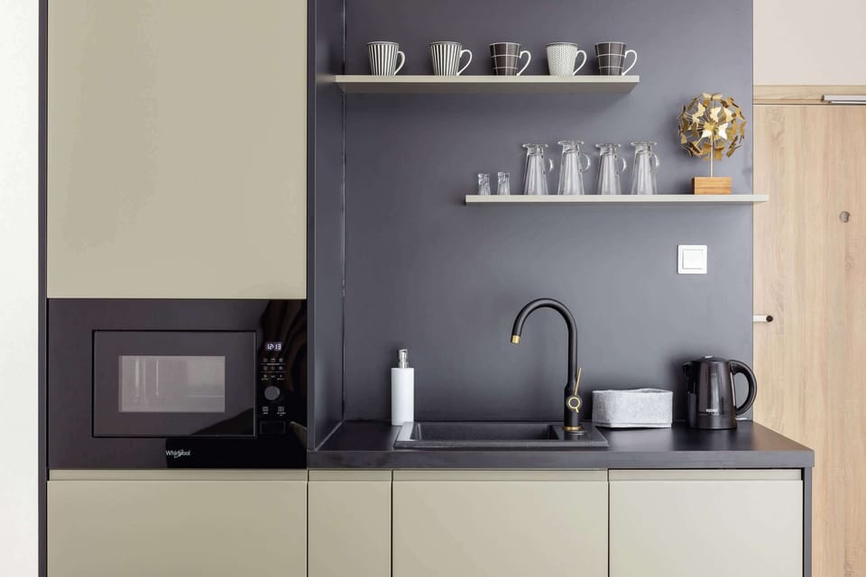 A compact kitchenette with sleek cabinetry, located near the entrance, combining style and practicality.