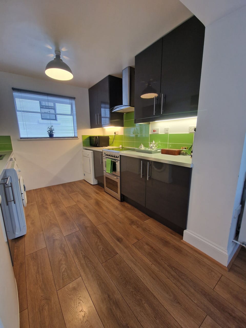 Modern kitchen with oven, hob, dryer, microwave and washing machine