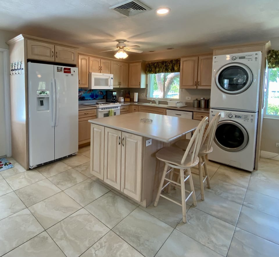 The kitchen is fully stocked with cookware, lots of dishes, and an island. 
