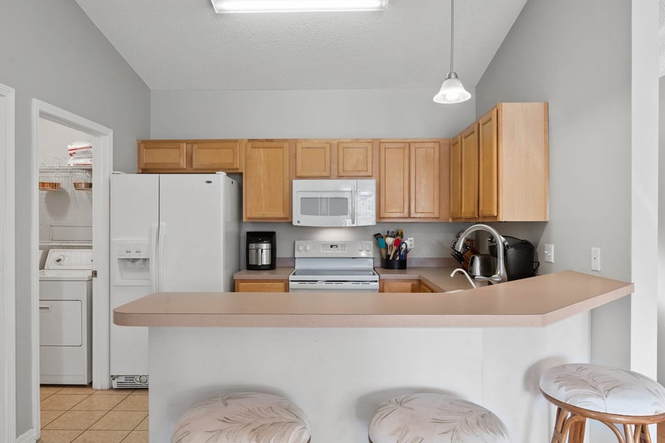 Cozy kitchen with full-size appliances, breakfast bar seating, and all the essentials—great for quick bites or full family meals.