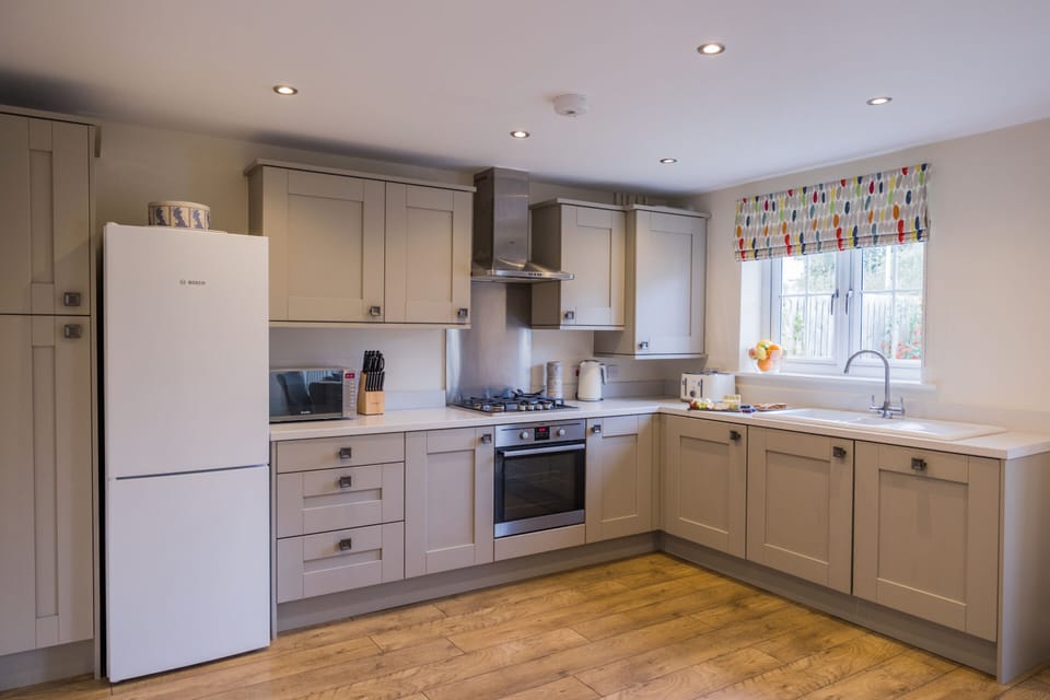 Electric oven, gas hob with washing machine and dishwasher either side of the sink