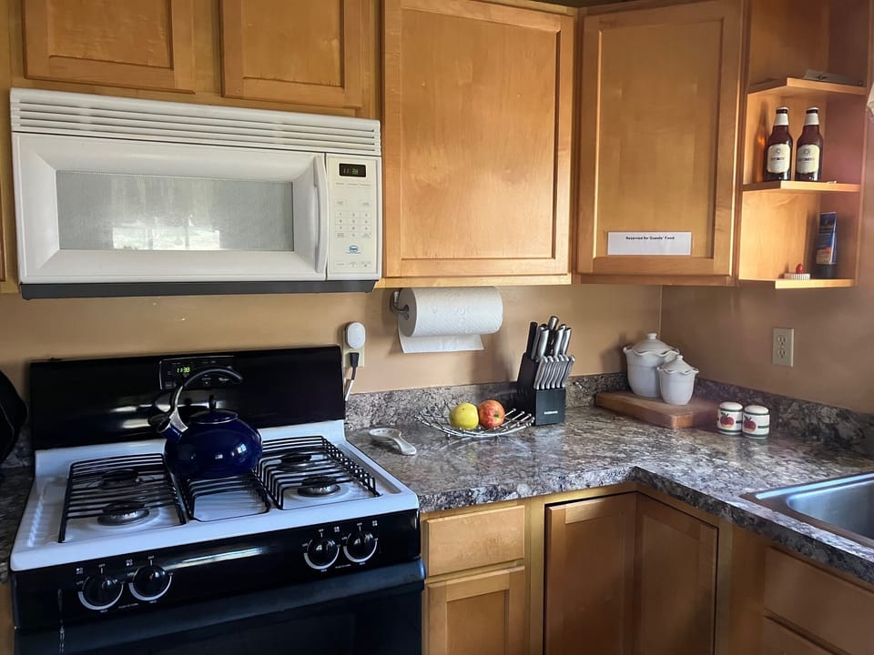 Gas stove, oven.   Workspace with Lazy  Susan - large assortment pots and pans.