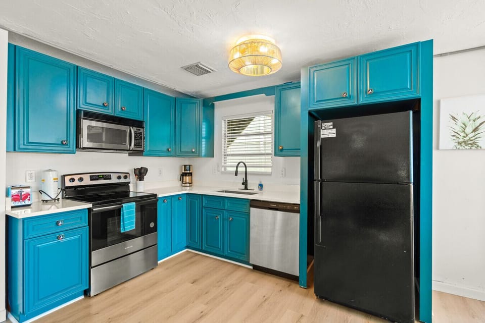 Siesta Key Beach Kitchen | Turquoise Cabinets, Sleek counter top & Bold Coastal Contrast