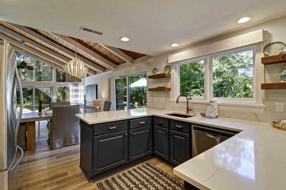 Kitchen open to dining and living area, views of side yard and pool