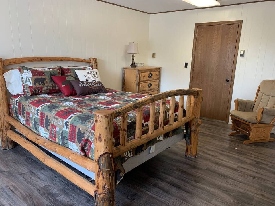 Another bedroom located on the main floor. Includes a queen size bed, a glider and a dresser.