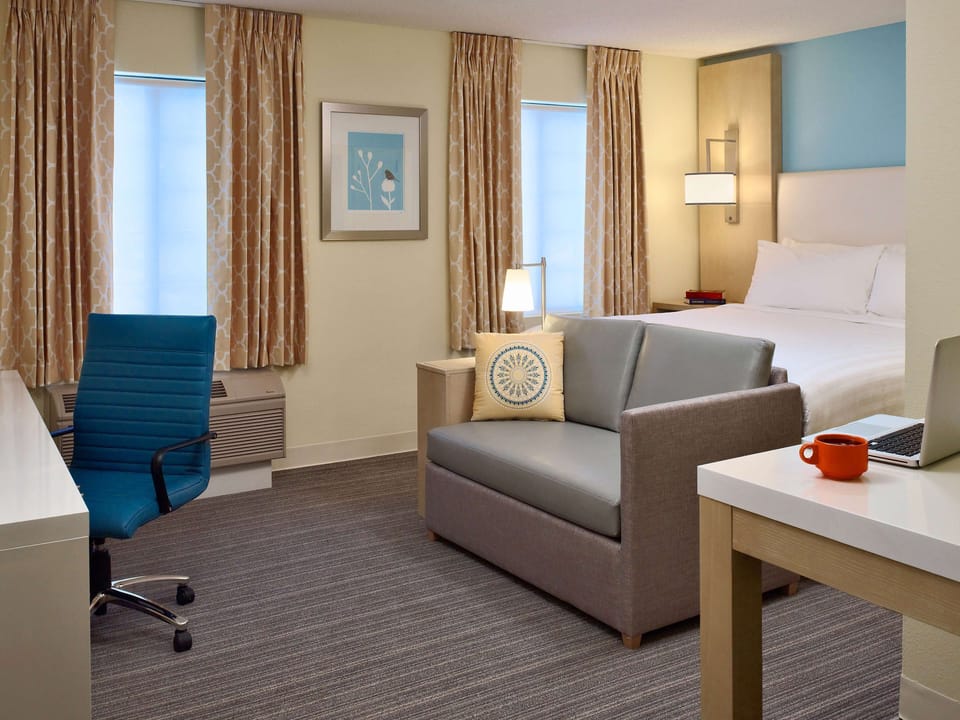 Unwind in a spacious suite with sofa, desk, and cozy bed.