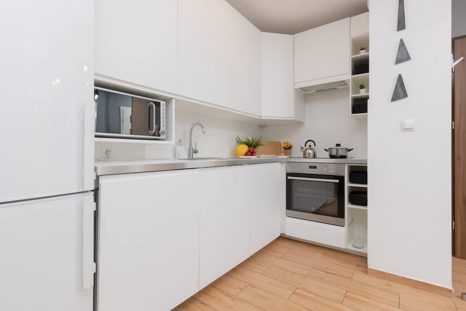 A modern, white kitchen with clean lines and integrated appliances, offering functionality and style.