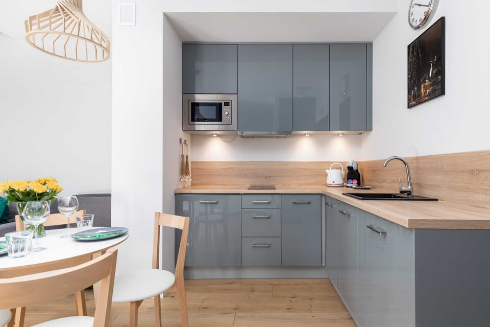 A modern kitchen with gray cabinetry, wood countertops, and built-in appliances, designed for efficiency and style.