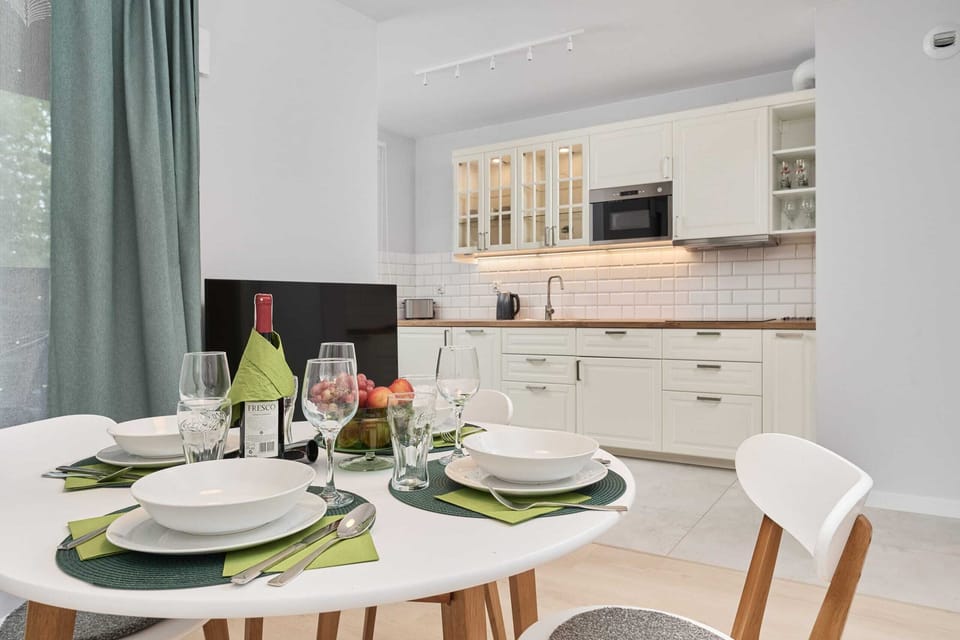 Modern dining area with elegant place settings for four, complemented by natural light and a serene color palette.

