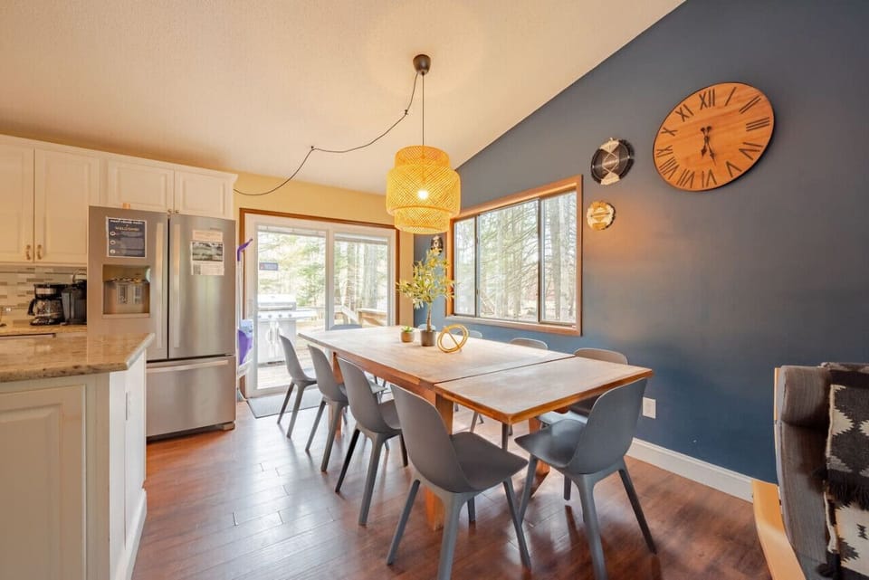 Cozy dining area with a wooden table, gray chairs, and stylish pendant light.