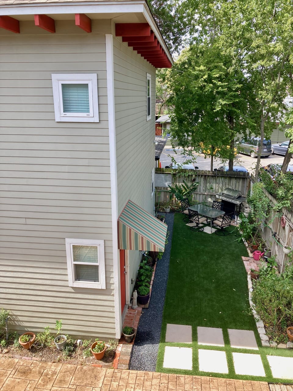 Landscaped side yard north of garage has propane grill and table for guest use.