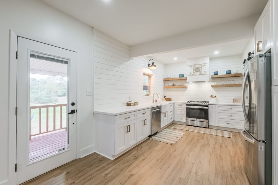 Open kitchen with gas range includes cooking and baking supplies.