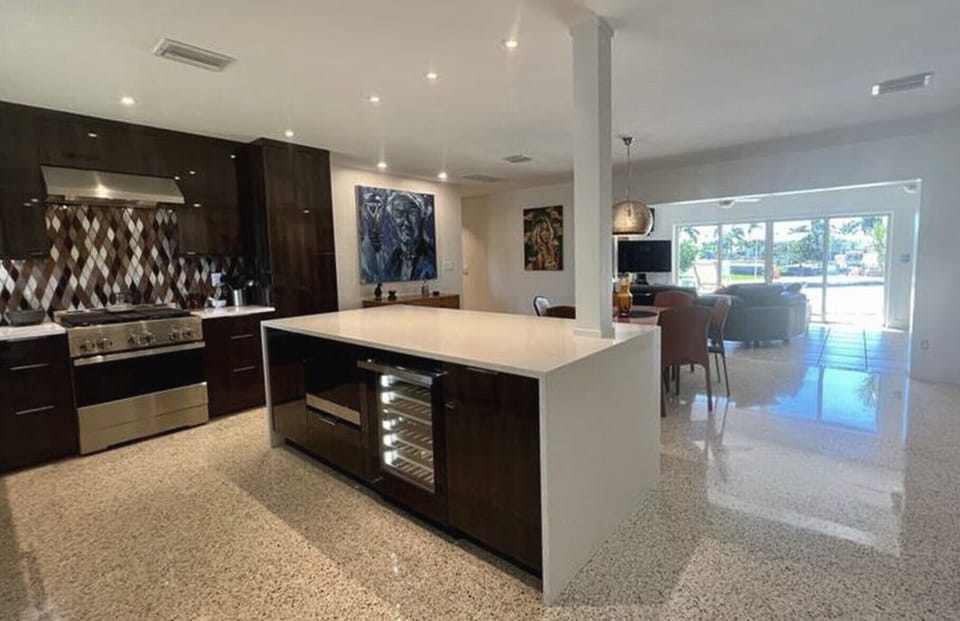 View from front door. Microwave and wine fridge in kitchen island.