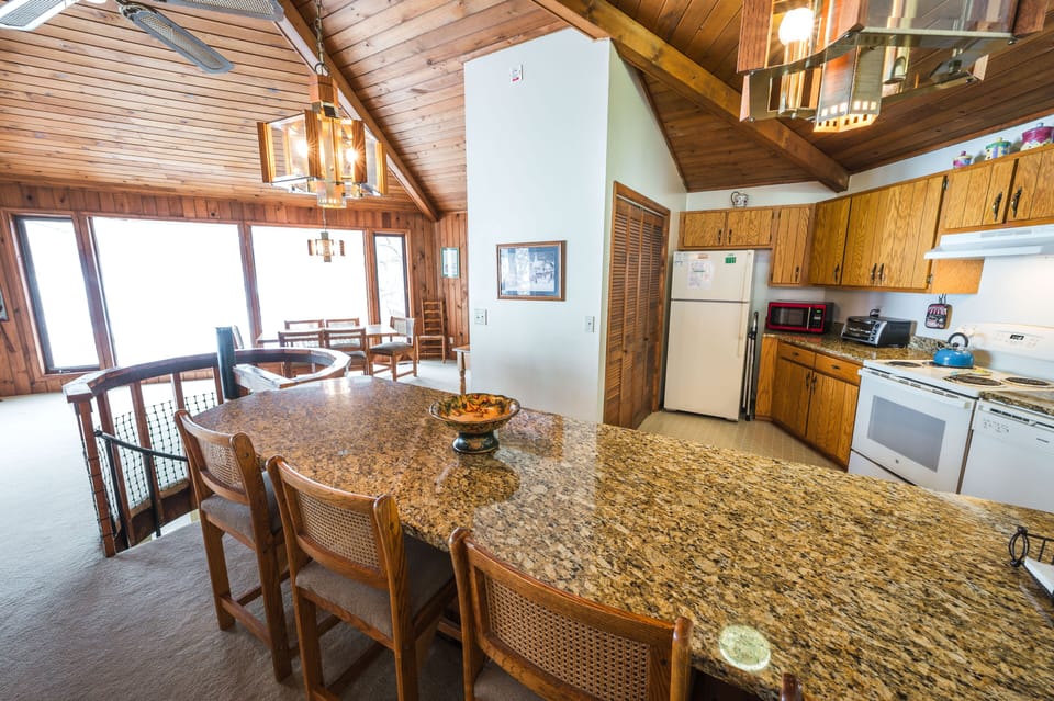 Open kitchen with granite countertops, bar seating, and wood accents.